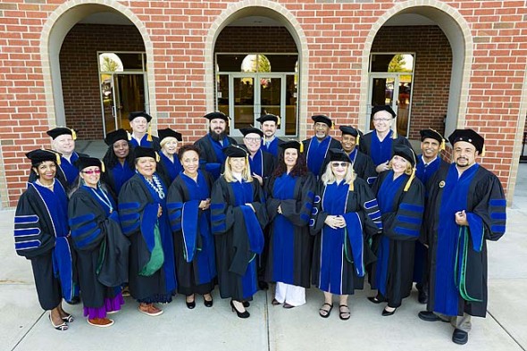 A group of graduates standing in their caps and gowns