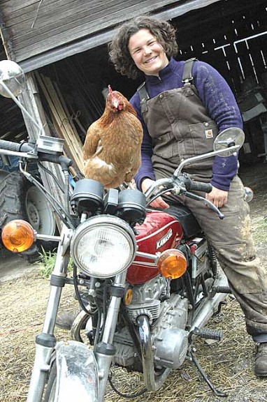 A layer hen perched on top of a motorcycle was not a strange sight at Amy Batchman’s new Radical Roots Farm on West Jackson Road, where Batchman plans to grow perennials, teach mechanics courses for women and move old barns. (Photo by Megan Bachman)