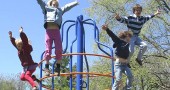 Kids leap into the blue spring sky