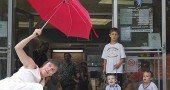 A mixed crowd of adults and children watched attentively as the dancers lunged up the library's front steps with colorful umbrellas as props. (Photo by Aaron Zaremsky)