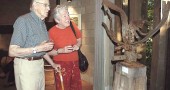 Bill Hooper and Jane Baker were among the many villagers who attended the Friday night reception for the art exhibit that features artwork inspired by the Glen. They are looking at "Glen Helen Raptor" by local sculptor Jon Hudson, created from scrap metal found in the Glen. (Photo by Diane Chiddister)