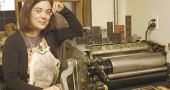 Artist Sarah Strong is shown with the letterpress in her village studio.