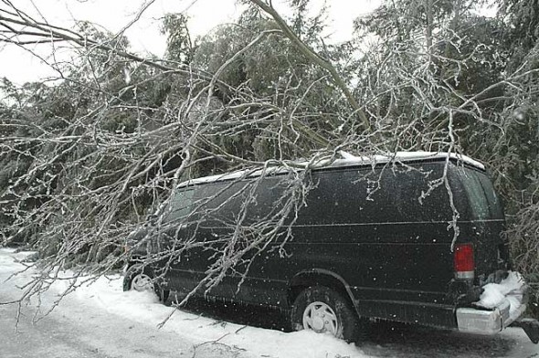 Not going anywhere soon: Last Wednesday morning a van on W. Davis Street seemed to shrink under the weight of the ice-covered tree that had toppled over during the ice storm the night before. Hundreds of limbs and branches fell during the storm, causing power outages all over the village. (photo by Lauren Heaton) 