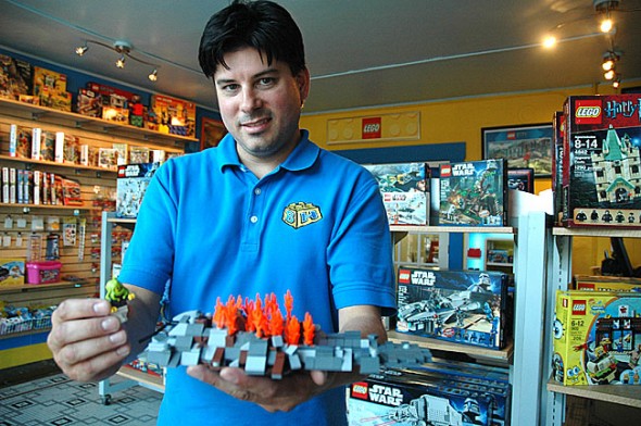 Kyle Peterson opened the Lego set and accessory store Blokhedz on Dayton Street last month. From the space he also runs Brick Forge, a successful minifigure customized accessory company that he started in his garage. Peterson, an Adult Fan of Lego, recently showed off a meteor crash he built for the store’s window display. (Photo by Megan Bachman)