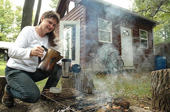 Ellen Dawson-Witt prepared tea in front of her 192-square foot off-the-grid cabin, in which she lived for one-and-a-half years. Dawson-Witt leads a seven-week course on “Choices for Sustainable Living” starting Tuesday, Oct. 1, at 7 p.m. (Photo by Megan Bachman)