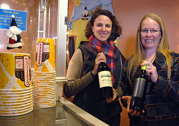 Little Art Theatre executive director Jenny Cowperthwaite-Ruka, right, and her assistant, Margaret Morgan, held up the wine that will soon be offered at the theater. The nonprofit recently received a license to sell beer and wine and will begin pouring drinks at a special showing of the film Sideways at 7 p.m. on Saturday, Dec. 17. (Photo by Megan Bachman)