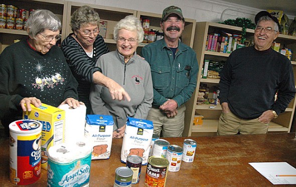 Food pantry volunteers Jean Shook, Patti McAllister, Jackie Hammond, Don Rudolf and Don Fulton put away donated items this week at the Yellow Springs Community Food Pantry in the basement of the Methodist Church. Demand for food and household goods at the pantry rises during th holiday season, and so do community donations. (Photo by Megan Bachman)