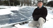 Eric Clark recently brushed off the snow from his new 20-panel solar photovoltaic array on the roof of the Springs Motel. The 4700-watt system will replace about 20 percent of the motel’s current electric load. (Photo by Megan Bachman)