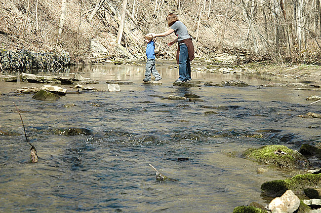 Hikers carefully navigated the stepping stones across Birch Creek in the Glen Helen Nature Preserve last weekend. The three local rivers that run through the Glen—Birch Creek, Yellow Springs Creek and the Little Miami River—drain runoff from village streets and area farms. Any contamination in the local watershed eventually makes its way into the Glen, impacting ecosystem health and recreational activities. (Photo by Megan Bachman)