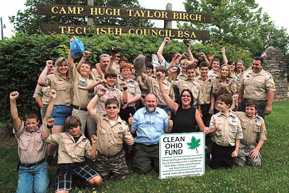 Boy Scouts at Camp Birch cheered at the news that Clean Ohio finally received funding for its open space and agricultural easement purchase programs. Last year Camp Birch used more than $600,000 from the statewide program to permanently protect the farms and wetlands at the 400-acre, 80-year-old camp. Pictured is Springfield Troop #311, along with, front center, Don Hollister of Ohio League of Conservation Voters and Krista Magaw of Tecumseh Land Trust. 