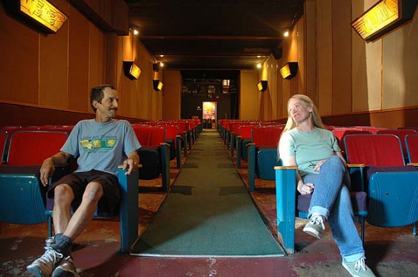 The Little Art Theatre is close to getting a complete renovation — the first in its 83-year history. Above, Little Art Executive Director Jenny Cowperthwaite and longtime 35-mm projectionist Andy Holyoke sit in the 37-year-old theater seats that will soon be replaced. (Photo by Megan Bachman)