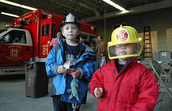 Kian and Neirin Barker learned all about firefighting at an open house for Miami Township Fire-Rescue last week. The Barkers were among the villagers who took a ride in a fire truck, explored the inside of an ambulance and watched a firefighter don the department’s heavy gear. (Photo by Megan Bachman)