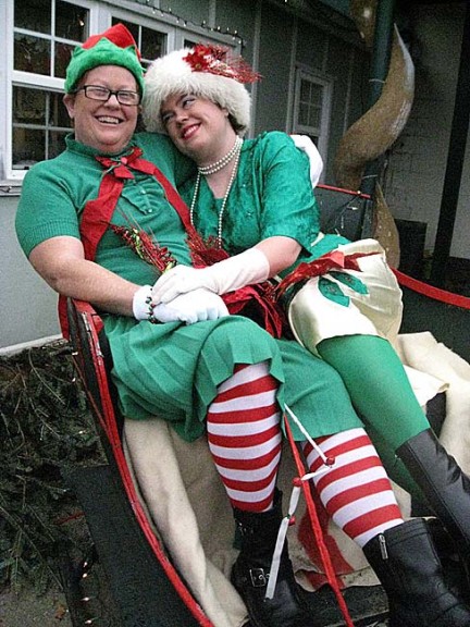 Penny Adamson, left, and Emily Seibel, shown above in the sleigh in front of the Yellow Springs Arts Council, were enthusiastic participants in last week-end’s Elf Tour, sponsored by the Chamber of Commerce. Those who dressed as elves last Saturday received discounts at local stores. (Photo by Susan Gartner)