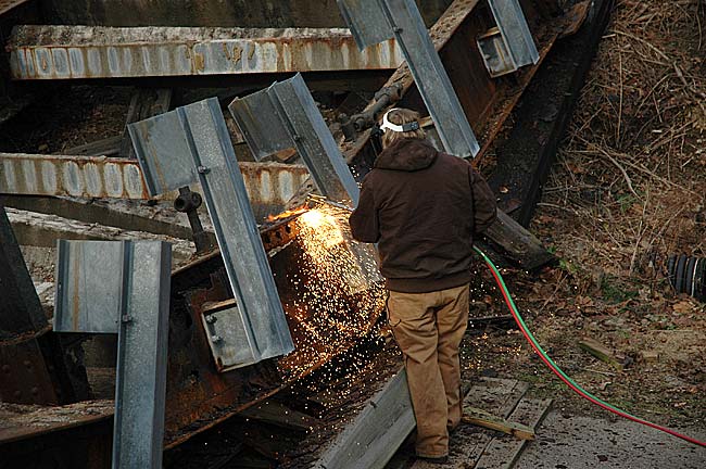 A Greene County road crew member took a blow torch to the steel girders to dismantle the bridge last week.