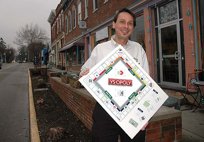 Brian Housh holds a copy of YS Opoly, a new Yellow Springs-based monopoly game, which is a fundraiser for the Yellow Springs Arts Council. Organizers are offering businesses and nonprofits who sponsor the game a featured place on the board. (Photo by Megan Bachman)