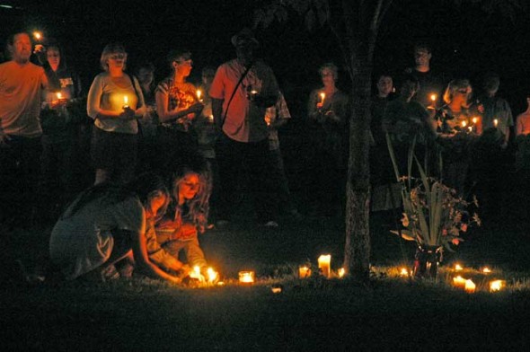 Villagers laid their candles under a tree at Mills Lawn in memory of Paul E. Schenck.