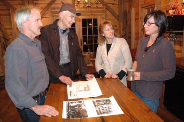 The Hammond family plans to model their Mills Park Hotel on the Barr property after the 1870 Mills House (see below). Pictured from left are Jim Hammond, Chamber of Commerce representative Roger Reynolds, and Libby and Katie Hammond, talking over the plans at the Grinnell Mill. (Photo by Lauren Heaton)