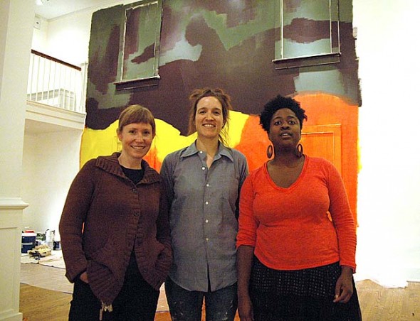 Antioch College’s art faculty members and resident scholars are exhibiting in “Currencies,” a new Herndon Gallery show running from Dec. 12–Feb. 14, with an opening reception from 7 to 9:30 p.m, Thursday, Dec. 12. From left are faculty members Sara Black, a sculptor, Raewyn Martyn, a painter, and Gabrielle Civil, a performance artist, in front of Martyn’s painting, portions of which will be peeled away to reveal new images during the course of the exhibit. (Photo by Megan Bachman)