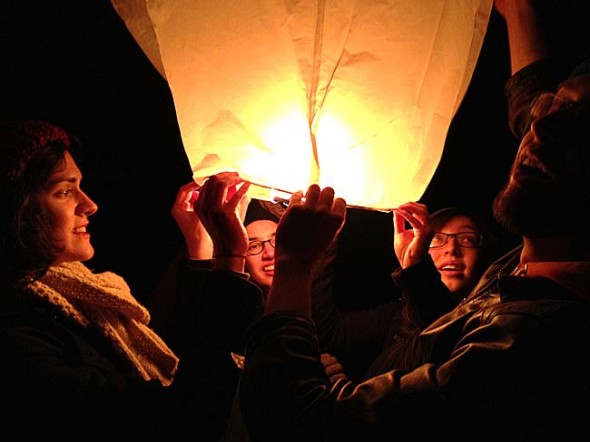 In March about 40 Antioch College students launched their “intentions”— inscriptions of their hopes and wishes on paper hot air balloons — before leaving for their first co-op term the following day. Pictured from left are Elaine Bell, Kijin Higashibaba, Cleo Van der Veen and Gabe Amrhein, about to release their balloon. (Photo by Matt Minde)