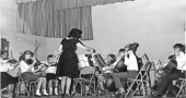 The Yellow Springs Summer Strings and Band Program will celebrate its 50th year as a summer music program for local children with a cello choir for alumni this Saturday, July 5, at 5 p.m., followed by a full orchestra performance. Shown above is an early concert with Summer Strings’ founder, Shirley Mullins, who continues to direct the program. (submitted photo)