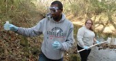 Last month, Wright State University students James Waweru, left, and Sarah Steele tested the water quality of Yellow Springs Creek near the Grinnell Road covered bridge. The Advanced Environmental Chemistry class tested 10 sites in and around Glen Helen Nature Preserve and found high levels of nitrates and E. coli in some springs and surface water and a private well. They will share their results at 3 p.m. Wednesday, Dec. 10, at the Vernet Ecological Center. (Photo by Megan Bachman)