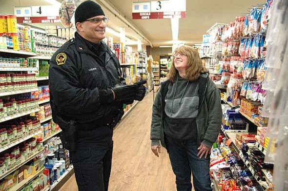 Yellow Springs Police Officer Brian Carlson talked to Brenda Donley at Tom’s Market during a recent Tuesday afternoon business rounds drop-in. Village police do a lot of routine patrols and vacant house checks, in addition to responding to calls for service. (Photo by Lauren Heaton )
