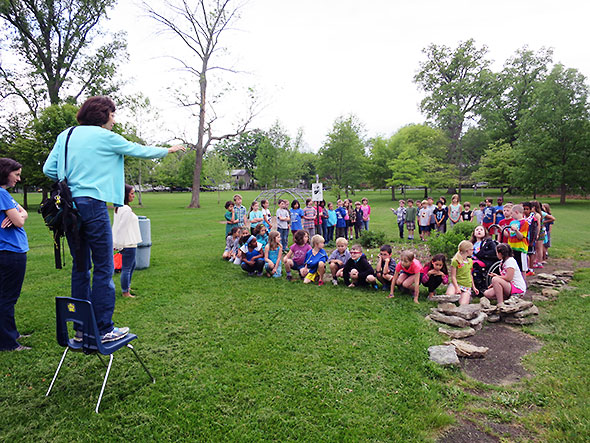 Nan Meekin sets up a photo capturing Mills Lawn 2nd grade students and their butterfly garden