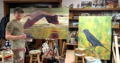 Travis Tarbox Hotaling worked in his studio on a painting of a heron for his upcoming show “Birding is Hard,” which will open at the Yellow Springs Brewery on Nov. 25, with a reception on Saturday, Nov. 28, from 3–5 p.m. His oversized paintings are a nod to the “involved and elusive” practice of birding while portraying the complex and fascinating personalities of his subjects. (Photo by Dylan Taylor-Lehman)