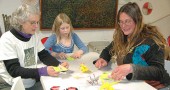 About a dozen villagers learned to make origami cranes, frogs and more last Saturday night at the Yellow Springs Arts Council, among them, from left, Fern Opotow, Areya Harker and Lara Bauer. (Photo by Audrey Hackett)