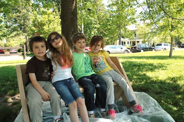 Kindergartners Zane, Maddy, Lian and Gracie seemed to prove the point of the newly installed Buddy Bench on the Mills Lawn School playground recently. The bench was constructed by students as a PBL project from wood of one of the many recently felled ash trees. (Photo by Carol Simmons)