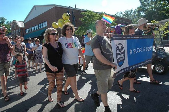 Under a hot summer sun several hundred villagers celebrated diversity and equality Saturday during Yellow Springs Pride events. Shown above at the fifth annual parade are Andi and DeLaine Adkins and Chris Wyatt of Scouts for Equality. (Photo by Diane Chiddister)