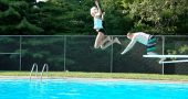The prosepect of hitting the water after a flying leap was made more attractive by the promise of a cool splash, as local Siobhan and her uncle Christian, visiting from Jamestown, saltoed through the summer air at Gaunt Park Pool last Friday. (Photo by Isaac Delamatre)