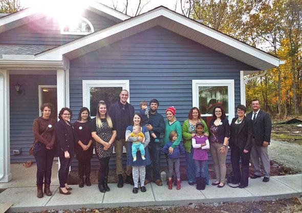 Pictured at the Home, Inc., Open House are, from left: Miller Fellow Monika Perry, AmeriCorps VISTA volunteer Cait Bothwell, Development Coordinator Brittany Parsons, homeowners Elizabeth and Matthew Schaade, homeowners Brandy and Patrick Hange with children Nico and Nolan, homeowner Erica Wyant with daughter Rudelle Mae, homeowner Julie McCowan, Miller Fellow Kyna Burke, Executive Director Emily Seibel and Program Manager Chris Hall. (Submitted Photo)