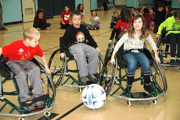 Above, from left, Nick Meister, Tyee Meeks and Ayla Arnold play soccer in sports wheelchairs brought over to the school from the Wright State Office of Recreation. (Photo by Robert Hasek)