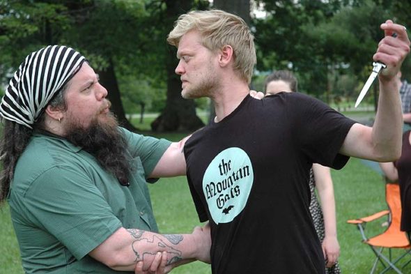 Aaron Saari (left), in the title role of Julius Caesar, and Jared Mola, as Brutus, rehearse the moment Caesar learns of his trusted comrade’s ultimate betrayal, in preparation for Yellow Springs Theater Company’s presentation of Shakespeare’s political tragedy, July 14–15 and 21–22, under the stars on the grounds behind Mills Lawn School. (Photo by Carol Simmons)