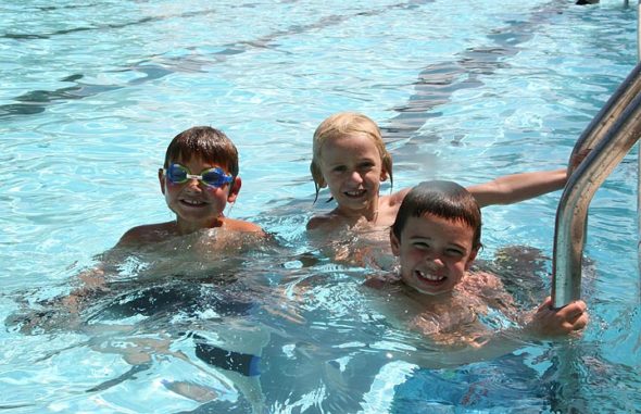 Monday afternoon local friends Edwin Harra, Ashby Lyons and Carson Funderburg enjoyed swimming at the pool on a rare day without showers. (Photo by Suzanne Szempruch)