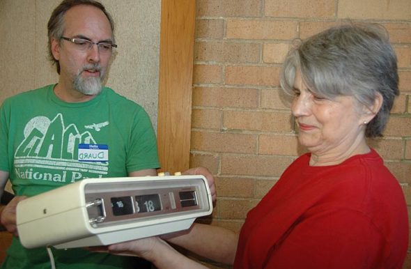 Deborah Dillon brought her “chirping” 46-year-old clock radio to last Saturday’s Repair Café, a free event for repairing household items such as clothing, furniture, lamps, computers and other small electronics. Duard Headley, also pictured, was one of the volunteer “fixers.” The Repair Café was organized by Kat Walter of YS Time Exchange. (Photo by Audrey Hackett)