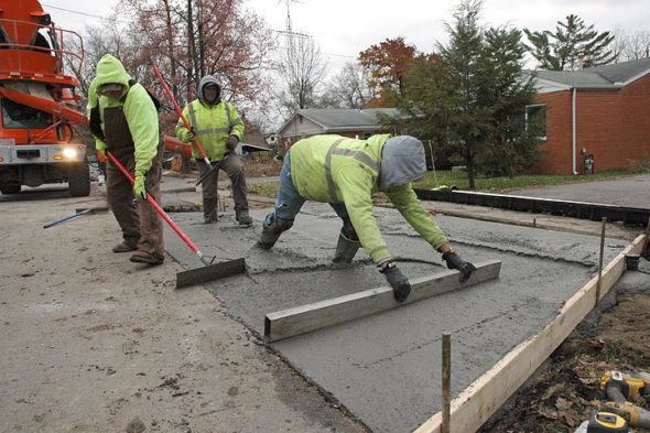 Several workers from Axis Civil Construction in Columbus poured concrete last week for a new sidewalk along the east side of Winter Street, part of the Safe Routes to School project. Shown above, crew leader Jacob Powell smoothed concrete after the pour. The project also includes a new section of sidewalk on Fairfield Pike from Fair Acres to Winter, in an effort to enhance safety for children walking to school. (Photo by Diane Chiddister)