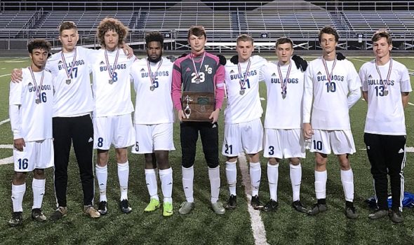 The Yellow Springs High School boys varsity soccer team’s seniors recently posed with their district runner-up medals and trophy. From left is David Walker, Calum Siler, Teymour Fultz, Tariq Mohammed, Dylan Rainey, Andrew Clark, Jesse Linkhart, Mateus Cussioli, and Ashton Gueth. The team had just lost a hard-fought match in the district finals, 6–4, on Oct. 25. (Submitted photo by Tracy Clark)