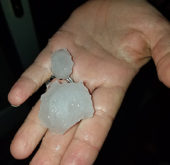 Village resident Bryan Cady holds two large hailstones that landed on his back porch Monday evening. 