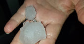 Village resident Bryan Cady holds two large hailstones that landed on his back porch Monday evening.