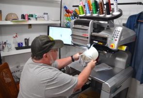 Mark Heise, co-owner of Yellow Springer Tees & Promotions, works his magic on his embroidery machine. All the apparel and adventure gear found at Yellow Springer Tees is custom-made and designed by either Mark Heise or his daughter, Morgan Heise. (Photo by Reilly Dixon)