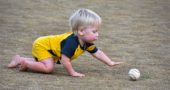 At a Perry League T-ball game earlier this month, one-year-old Ronan Triplett crawled down for a ball. (Photo by luciana Lieff )