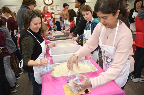 About 50 adults and kids took part in last week’s meal-packing event for the Kid Scouts Hunger Van, which took place at the Senior Center Great Room. Pictured above, from left, is Kelley, Sage and Cole Oberg, and Jyoti Miller. (Photo by Diane Chiddister)