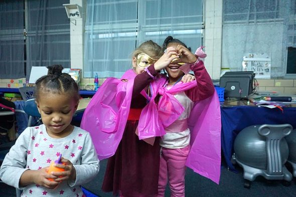 Preschooler Bella Dishmon, daughter of Intervention Specialist Olivia Dishmon, shows her bottle of bubbles while superhero friends Lisbeth Swanson and Olive Dishmon share a “heart” moment. (Photo by Carol Simmons)